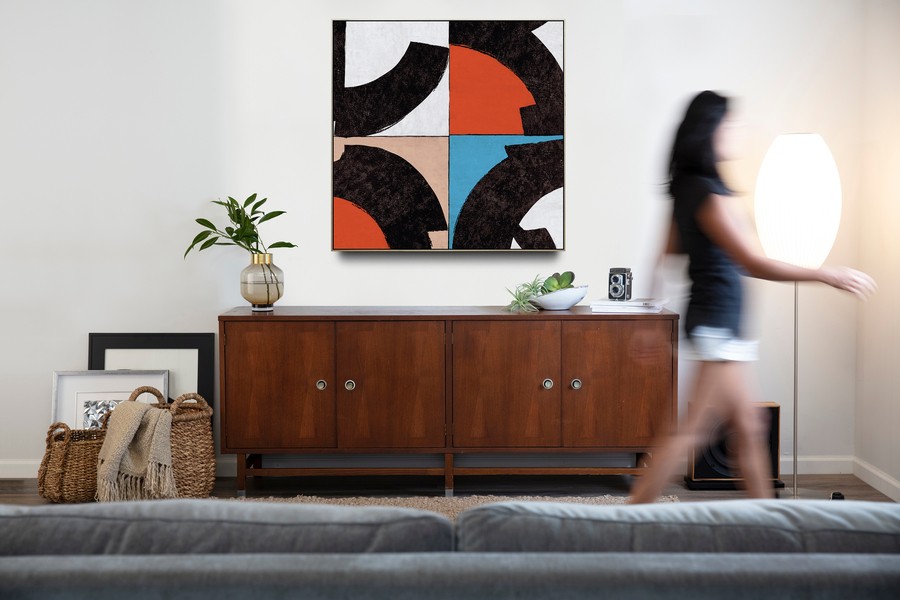 Una mujer camina por la sala, mientras una bocina de Leon Speakers reproduce contenido de audio.